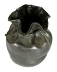 Black ceramic vase with ruffled rim and textured, rounded body, shown on tabletop for display.