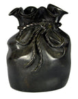 Close-up of a bronze ceramic vase shaped like a tied pouch with braided rope detailing on a tabletop.