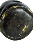 Close-up of bronze metal paperweight base with scuffs, gold-toned edges, showing worn, flat surface.