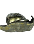 Close-up of bronze snail sculpture with detailed shell, solid metal design, shown as a desktop paperweight.