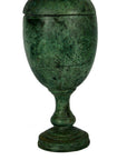 Green weathered bronze urn with lid, wide body, narrow stem, and round base on a white background.