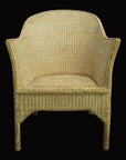 Natural rattan chair with curved armrests and rounded back, set against a solid black background.