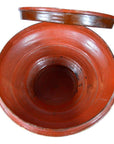 Red clay Burmese offering bowl with open lid, gilt accents, and smooth glazed interior, close-up.