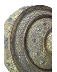 Close-up of a gold and bronze Burmese offering bowl with ornate floral patterns and embedded stones.