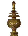 Gold Burmese offering bowl with gilt finial, intricate patterns, and layered pointed top on white background.
