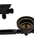 Close-up of a dark, geometric metal candle holder with circular and rectangular shapes on a white background.