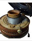 Silver metal oil kerosene stove with round burner and open lid, close-up.