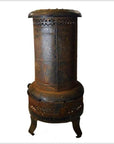 Black metal cylindrical oil or kerosene stove with three short legs, vintage style, shown on a plain background.