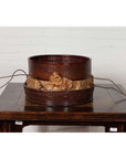 Black wood Chinese 19th century tiered food basket with stacking parts on a dark wood table, white brick wall background.