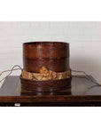 Black lacquered Chinese 19th century wooden tiered food basket with stacking parts on a wooden table indoors.