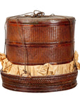 Brown woven Chinese 19th century tiered food basket with stacking parts, lid, and rope handles on a plain background.