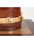 Close-up of a brown wood Chinese 19th century tiered food basket with stacking parts and crumpled paper on dark wood.