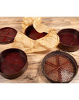 Brown wooden round baskets with stacking sections, including a Chinese tiered basket, on a wood floor indoors.