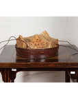 Dark wood Chinese 19th century tiered food basket with stacking parts on a dark wood table against a white brick wall.