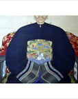 Blue and gold Chinese ancestor painting on linen canvas, seated figure with folded hands, close-up view.