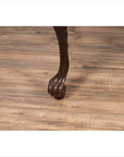 Close-up of dark wood cabriole leg table with black lacquered top on light wood floor indoors.