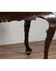 Close-up of black lacquered wood Chinese antique center hall table with cabriole legs on wooden floor indoors.
