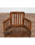 Brown bamboo child's corner chair with hexagonal base on a wooden floor next to a white wall indoors.