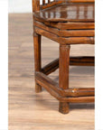 Close-up of brown bamboo and wood child’s corner chair with hexagonal base on light wood floor.
