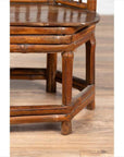 Close-up of brown bamboo Chinese antique child's corner chair with hexagonal base on light wood floor.
