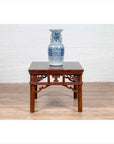 Blue and white ceramic vase on dark wood Chinese antique side table with open fretwork design, close-up view.