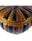 Close-up of a round bamboo rice basket with ribbed gold and black body, scalloped design, and metallic finish.