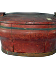 Red bamboo oval basket with metal band, worn paint, lid partially visible, shown in good condition.