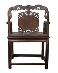 Brown carved rosewood Chinese chair with ornate backrest and armrests, front view on white background.