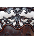 Dark rosewood Chinese chair with ornate floral carvings and central skull motif, early 20th century, front view.