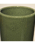 Close-up of pale green crackle celadon porcelain vase, viewed from top and side, against plain background.