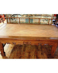 Brown wood Chinese daybed with woven rattan surface and carved legs, placed on a wooden floor.