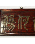 Close-up of dark red-brown elm wood sign with large gold Chinese characters.