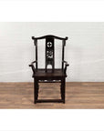 Dark patina Chinese elmwood Dengguayi scholar's chair on wooden floor, white brick wall background.