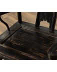 Close-up of dark patina elmwood chair with scratches and carved backrest, 19th century.