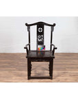 Dark patina elmwood chair with carved details and decorative backrest, shown indoors.