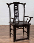 Dark patina elmwood scholar's chair on wood floor with white brick wall background.