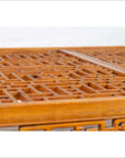 Close-up of warm brown elmwood square coffee table with open fretwork and horse-hoof legs, indoors.