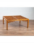 Brown elmwood square coffee table with open fretwork and horse-hoof legs on a wood floor indoors.