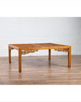 Brown elmwood square coffee table with open fretwork and horse-hoof legs on a wood floor.