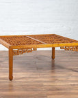 Brown elmwood square coffee table with open fretwork and horse-hoof legs, indoor setting.