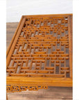 Brown elmwood square coffee table with open fretwork and horse-hoof legs on a wood floor indoors.
