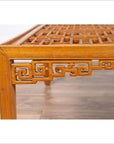 Close-up of dark wood square coffee table corner with open fretwork detail and curved horse-hoof legs.