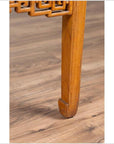 Close-up of brown elmwood square coffee table with horse-hoof legs on light brown wood floor indoors.