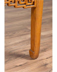 Close-up of brown elmwood square coffee table with horse-hoof legs on light brown wood floor indoors.