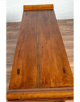 Brown glossy wooden table next to a brown Chinese Elmwood two-door low cabinet with everted flanges indoors.