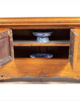 Brown elmwood two-door low cabinet with everted flanges, doors open showing blue and white ceramics inside.