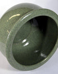 Green celadon ceramic bowl with crackle glaze, side view, set against a white background.