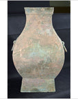 Dark bronze Hu vessel with wide body, square top and base, and side handles, close-up against a dark background.