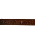 Brown carved wood plaque with swirling patterns and a rectangular center on a plain white background.