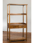 Tall wooden bookcase with three shelves and two drawers on a wooden floor.